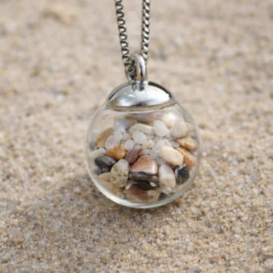 Steine und Muscheln in Glasperle hängt an einer Edelstahlkette